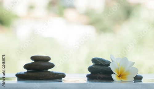 Two sets of spa objects and stones on white table with sunlight