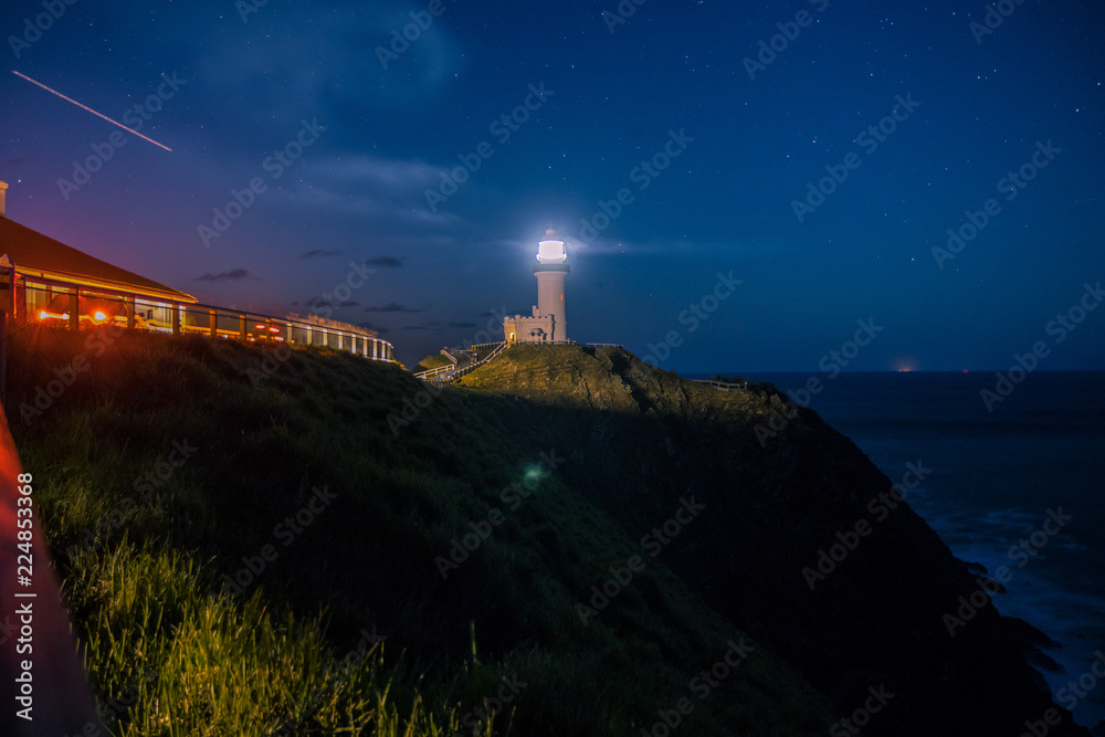 Lighthouse illuminating at cliff at night