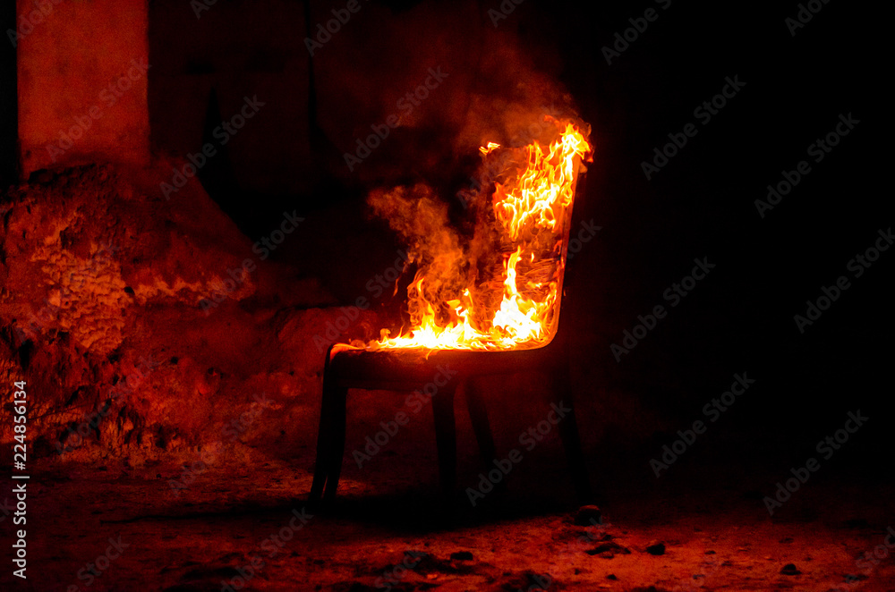Wooden chair is on fire. Incineration of furniture. Conceptual photo, burnout - obrazy, fototapety, plakaty 