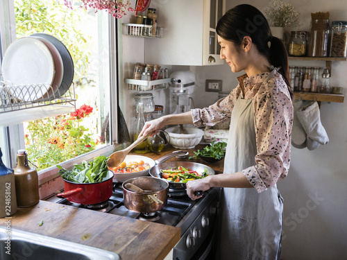 Cuadro en lienzo Woman cooking lunch in a kitchen
