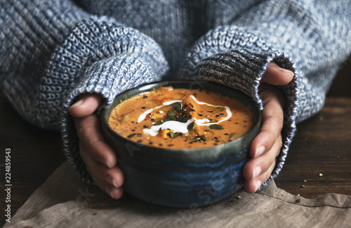 Canvas Print Female hands holding a bowl of pumpkin soup