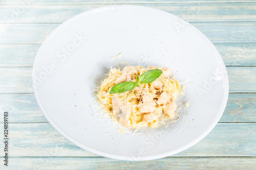 Plate of pasta fetuccini with salmon and parmesan cheese photo