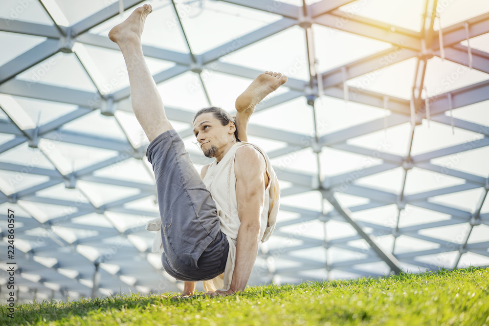Close up of attractive athletic man practicing yoga and warming up outdoors. Close up of attractive athletic man practicing yoga and warming up outdoors.