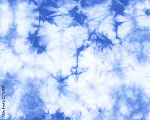Abstract tie dyed fabric of indigo color on white cotton. Hand painted fabrics. Shibori dyeing photo