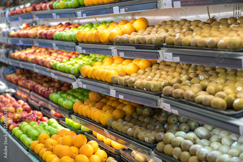 Fresh healthy fruits on shelves in supermarket