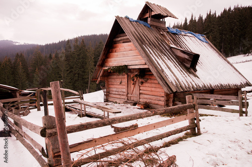 A wooden house in a clearing. Winter landscape with a house. photo