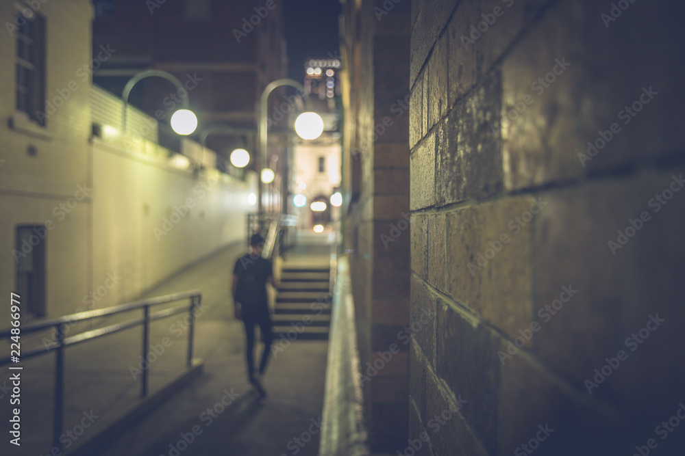 Blurred view of man walking on dark street