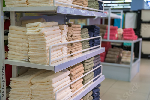 Stacks of colored towels on the shelves in supermarket