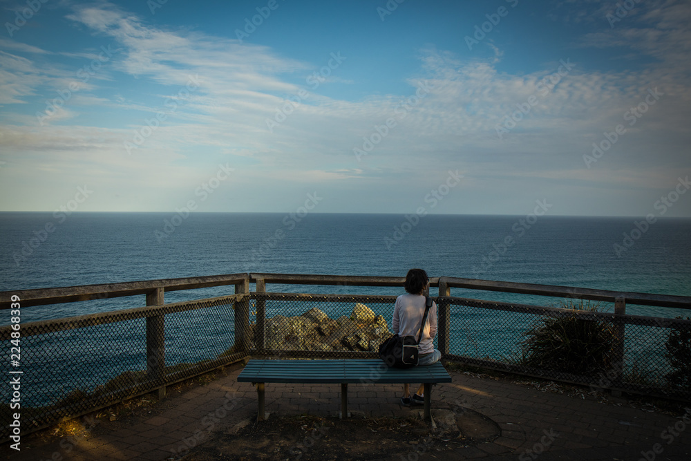 Woman on bench with seascape