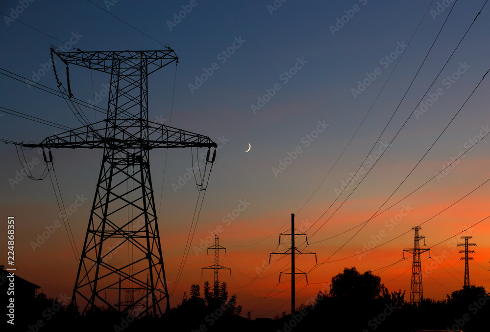 Electrical lines under a night sky with moon.