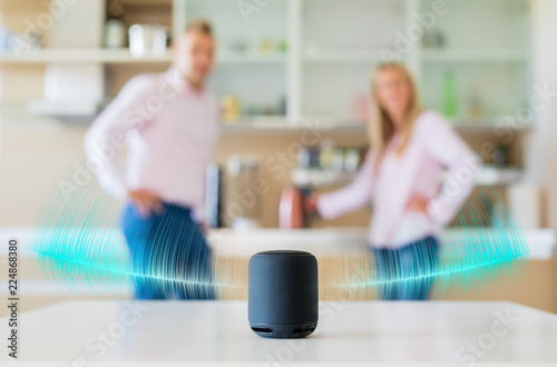 Couple talking and listening to smart speaker at home