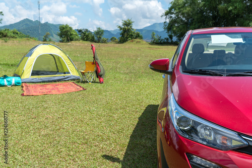 Car beside tent camping on grass field. Outdoor activity