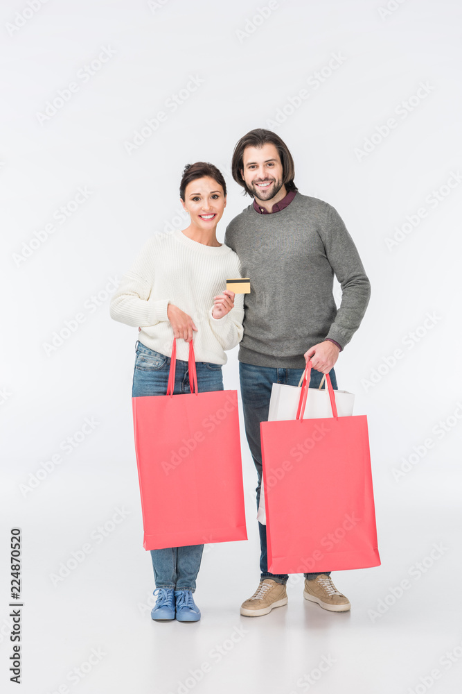 smiling couple with shopping bags and woman showing credit card isolated on white smiling couple with shopping bags and woman showing credit card isolated on white