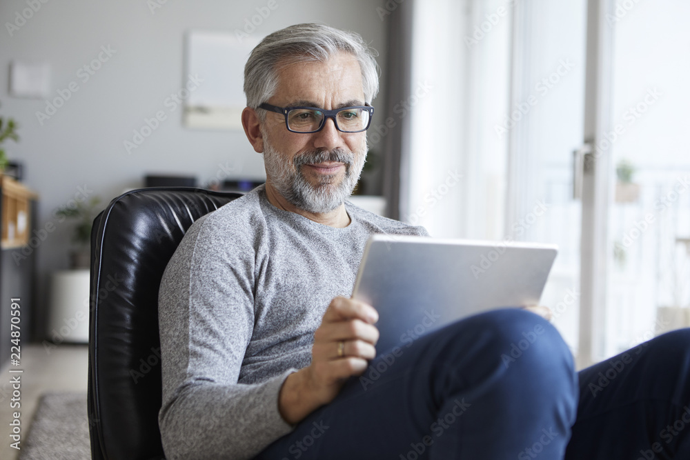 Portrait of mature man using tablet at home Portrait of mature man using tablet at home