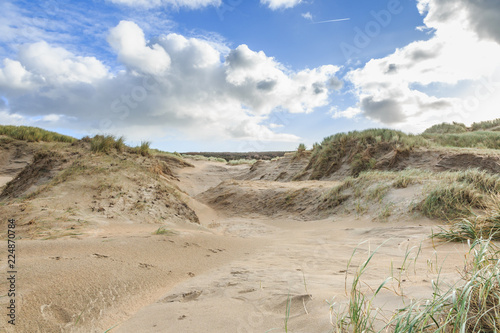 Bild auf Leinwand Dune valleys with deep wind holes carved out by heavy storm with swaying marram