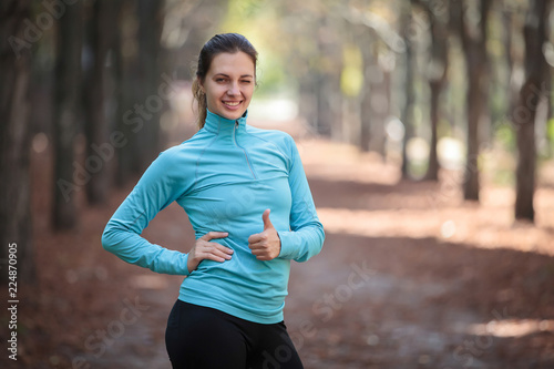 The sports girl in the park is happy and joyful.