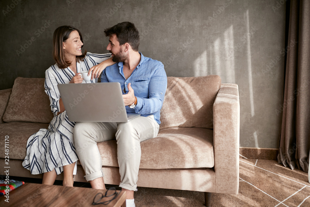 couple relaxing on sofa with laptop. Love, happiness, people and fun concept. couple relaxing on sofa with laptop. Love, happiness, people and fun concept.