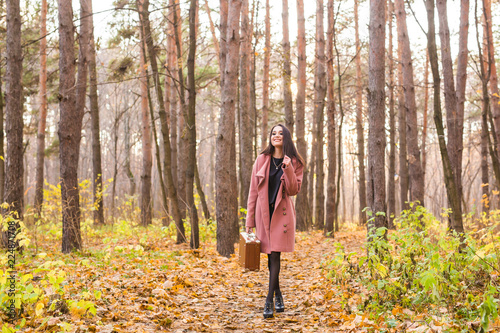 Fall, season and people concept - young woman walking in park at autumn © satura_