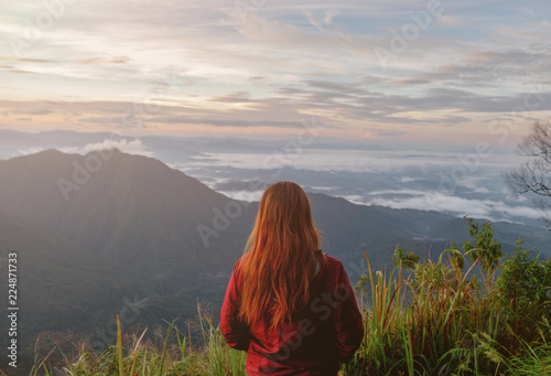 Cute girl hiking adventure on the high mountain with beautiful views of mist. at Doi Phu Kha in Nan.