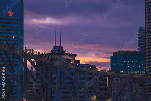 People on city bridge in evening