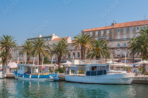 Split, Croatia. Europe. Sea banks with mooring tourist excursion boats. In background Saint Domnius bell tower.