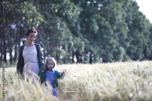 A young mother walk in wheat fields
