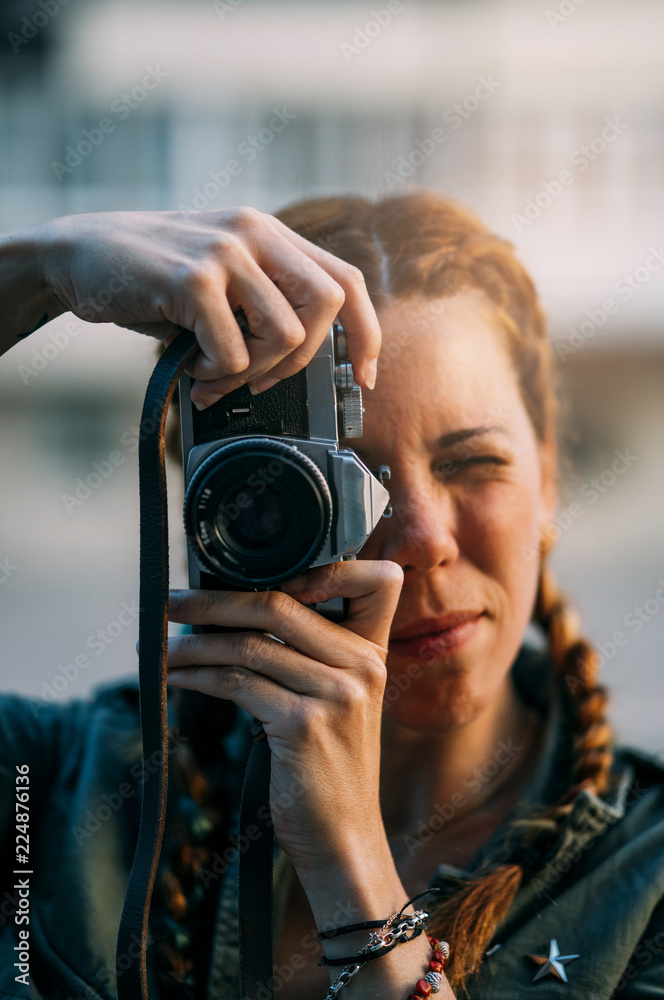 Pretty redhead girl with braids taking pictures. Pretty redhead girl with braids taking pictures.