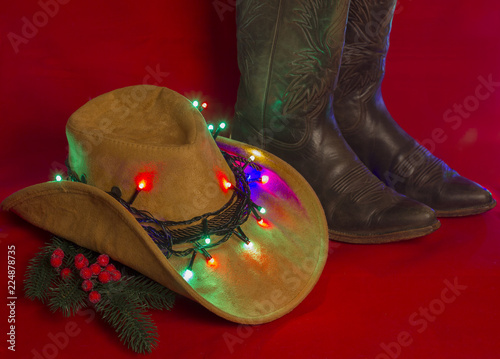 Cowboy Christmas.American West traditional boots on christmas red background