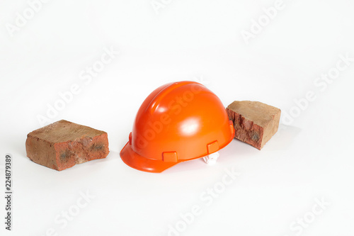 Construction helmet and brick on a white background