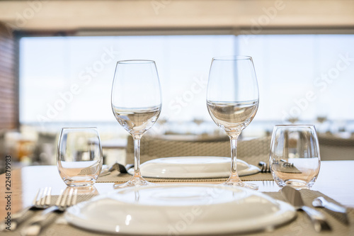 Table with plates, glasses and silverware in an elegant restaurant
