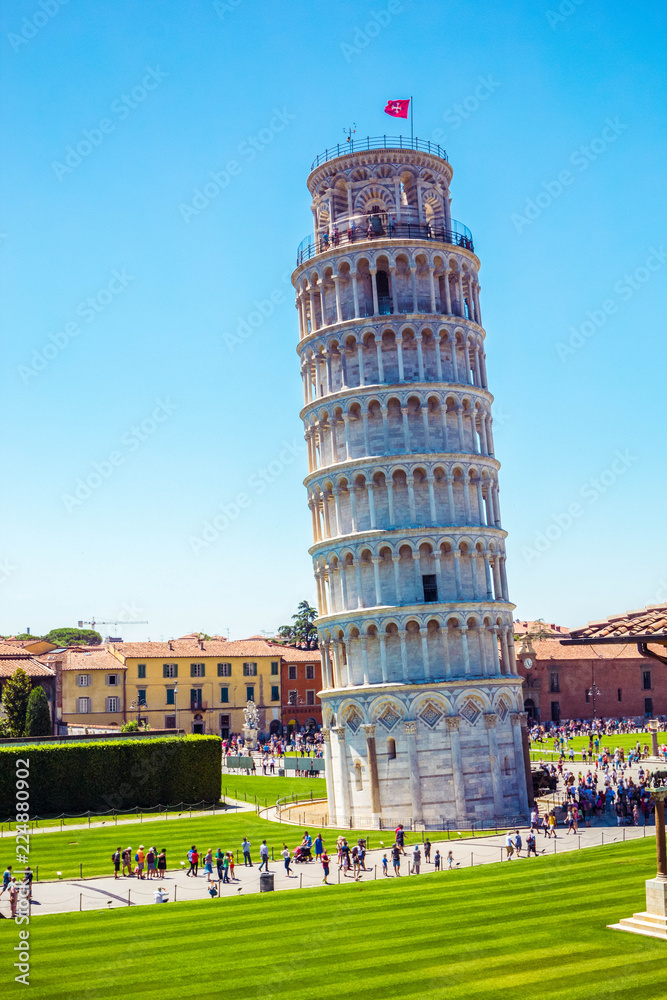 Leaning Tower, famous inclined tower of Pisa with green lawn in Pisa, Tuscany, Italy