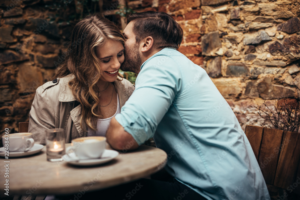 Romantic couple on a date sitting in a restaurant - obrazy, fototapety, plakaty 