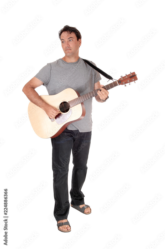 A tall man standing playing his guitar A tall man standing playing his guitar