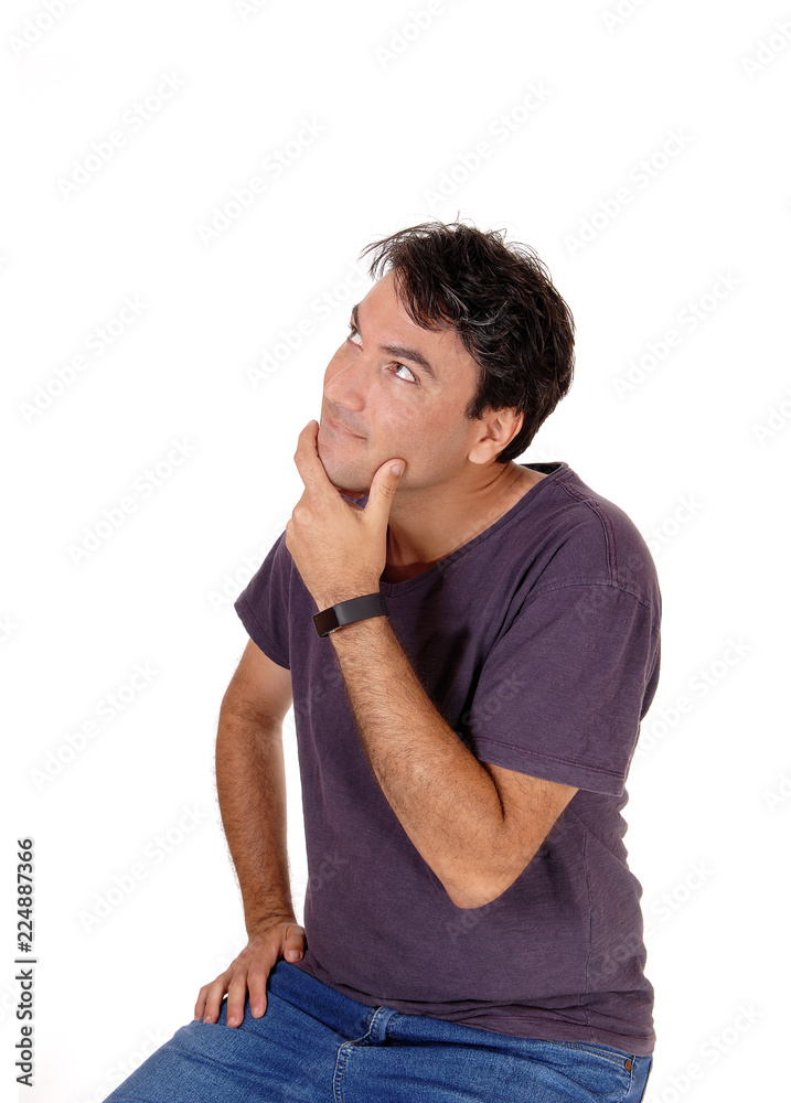 Puzzled young man with his hand on chin
