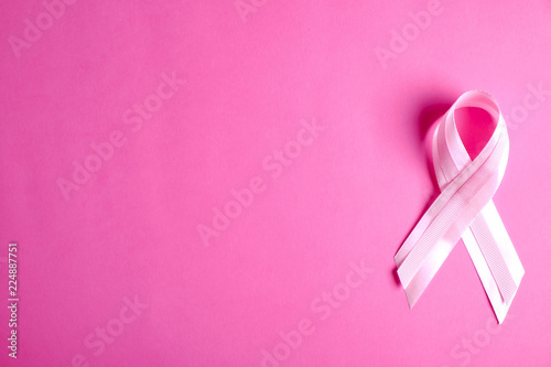 The pink colored ribbon - international symbol of breast cancer awareness and moral support for women. Isolated background, copy space, close up, top view fat lay.