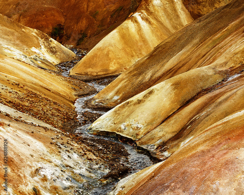 Strongly structured landscape in ocher and brown tones with a small river - Location: Iceland, Highlands, area 'Kerlingarfjöll'