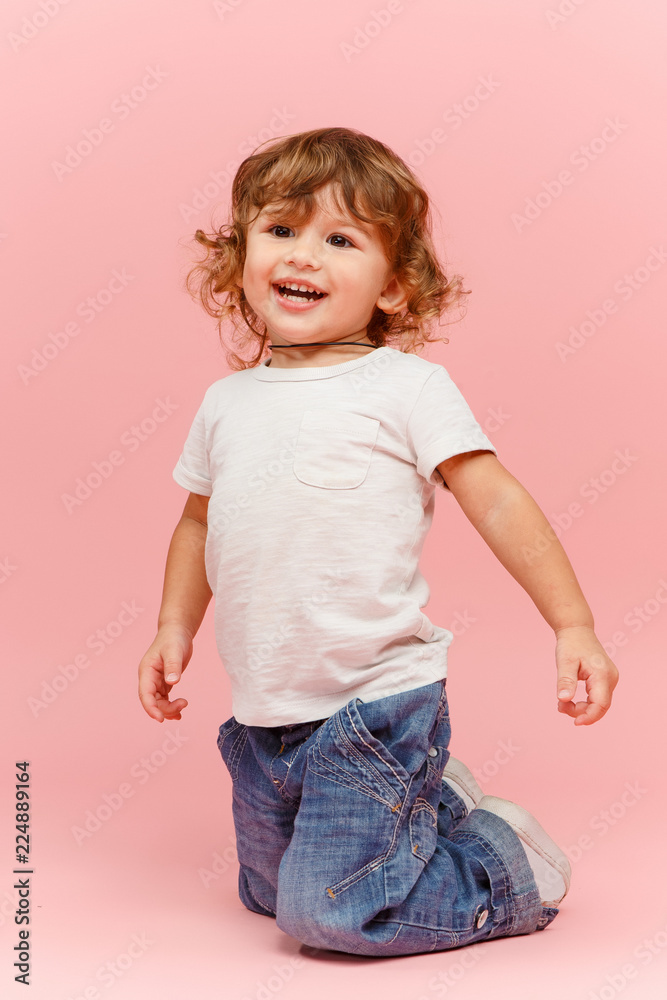 Portrait of happy joyful beautiful little boy, studio shot on pink