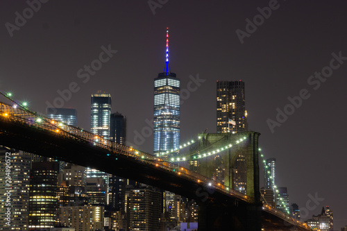 New York City Manhattan downtown skyline and Brooklyn Bridge at night viewed from Brooklyn Bridge park