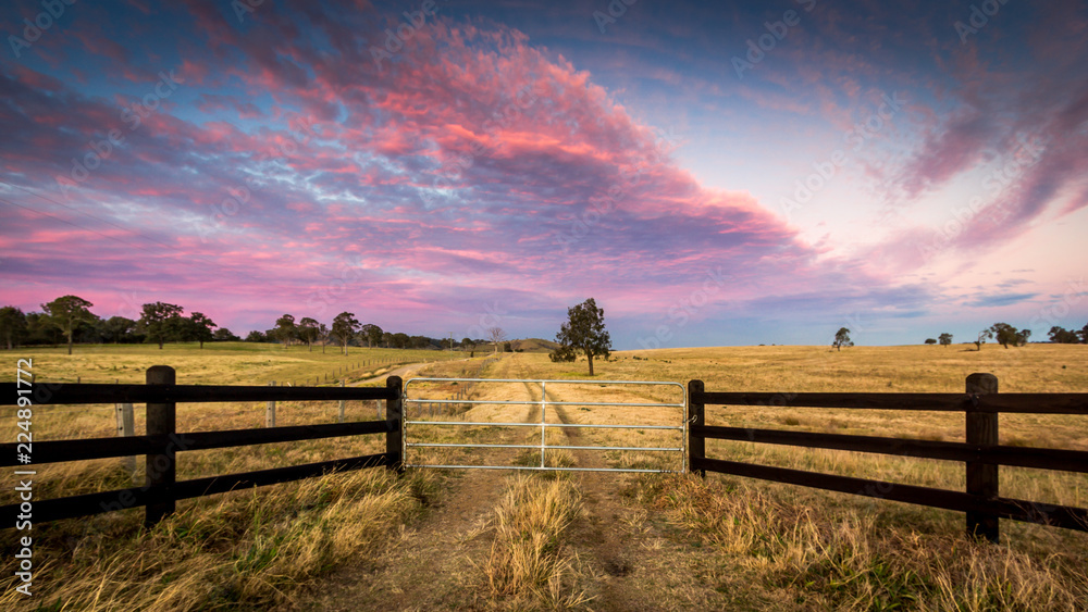 Colourful sunset in rural setting with wooden fence