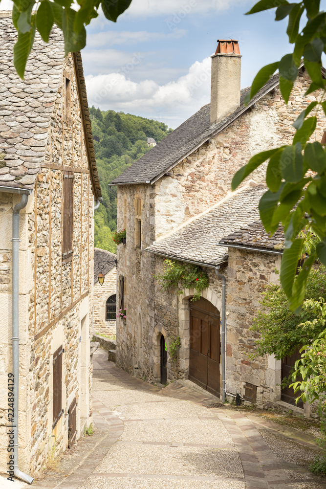Village street with ancient walls and houses in village of Najac, Aveyron, France