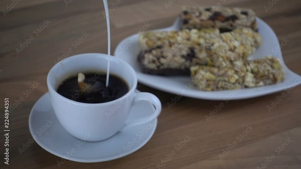 Pouring cream into coffee in slow motion (20x speed). Healthy breakfast concept 