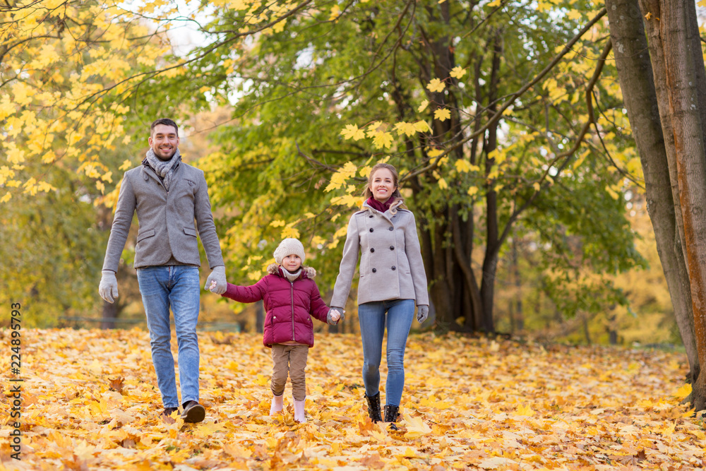 family, season and people concept - happy mother, father and little daughter walking at autumn park