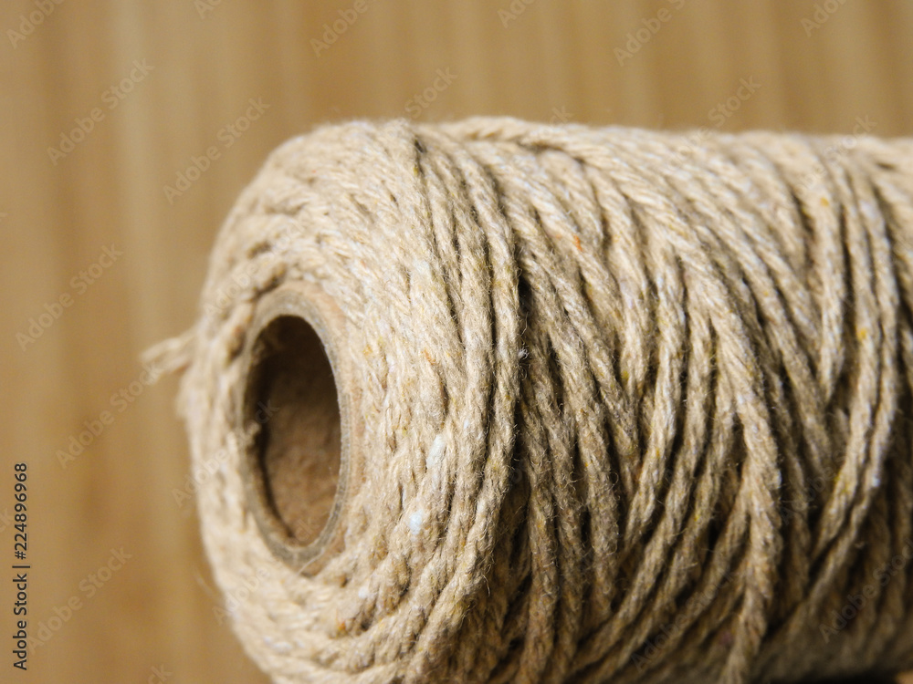 Close up of bundle of round brown thin hemp rope with fiber