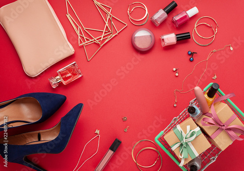 Flat lay of women's accessories over the red background. Sales, shopping, gift ideas concept with copy space.