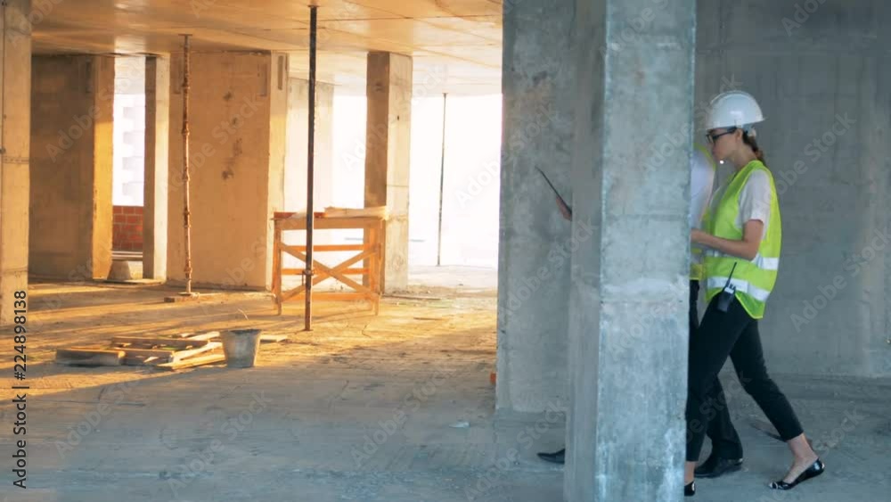 Two engineers are walking along the construction site. Two engineers are walking along the construction site.