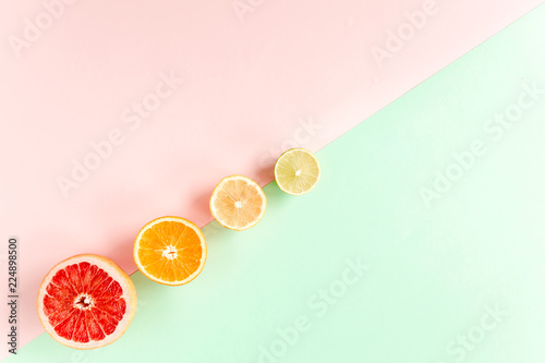 Creative pattern made of summer tropical fruits  grapefruit  orange  lemon  lime on colorful background. Food concept. flat lay  top view