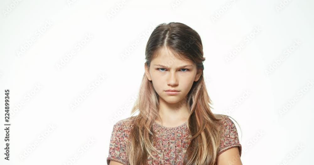 Angry teenager looking at camera on the white background. Close up portrait Angry teenager looking at camera on the white background. Close up portrait