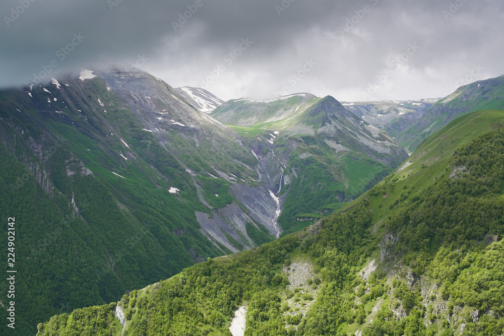 Mountain landscape, green peaks and clouds.