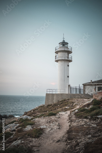 Lighthouse Faro Cabo Touriñán in Spain in evening guiding way for shifs at rough coast