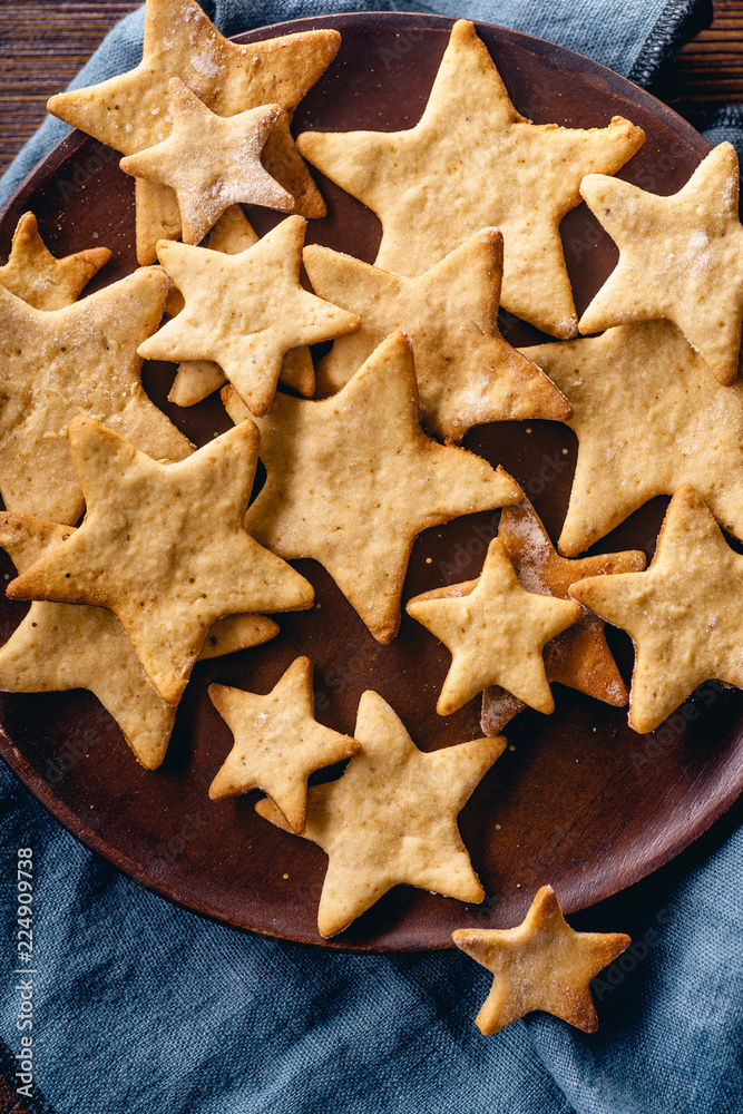 Swedish ginger cookies in a star shape on wooden table. Flatlay, overhead composition. Christmas atmosphere